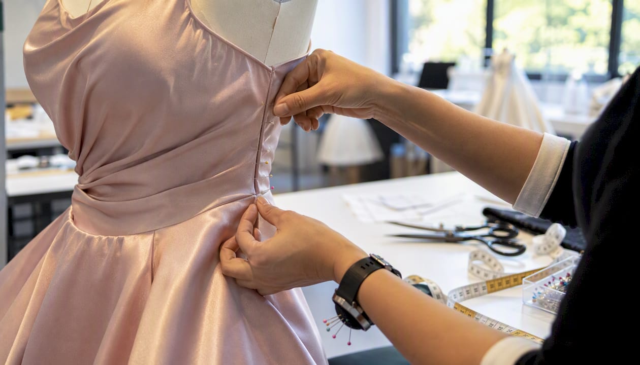 Hands pinning side seam of formal gown