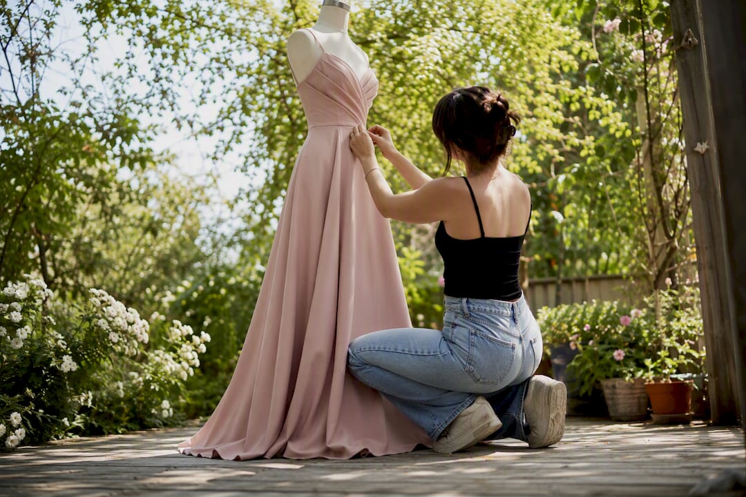 Petite woman adjusting evening gown silhouette