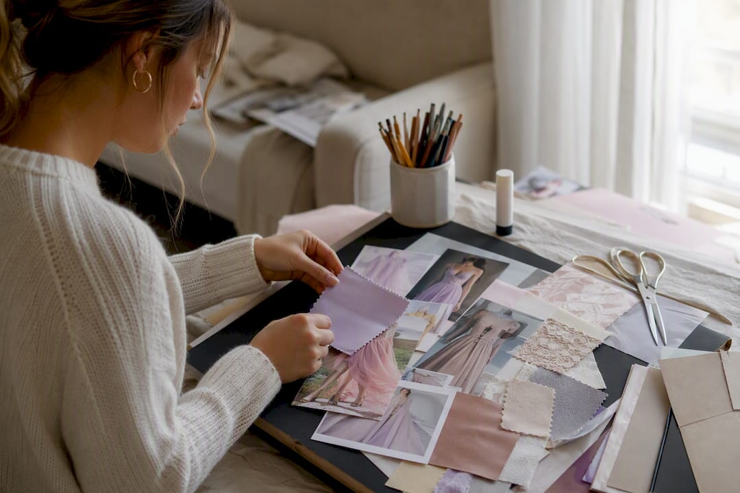 Hands assembling fashion vision board with fabric swatches