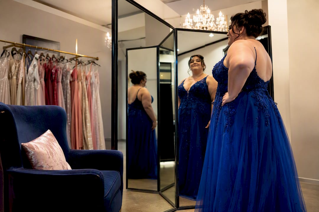 Plus size woman checking gown profile in mirror