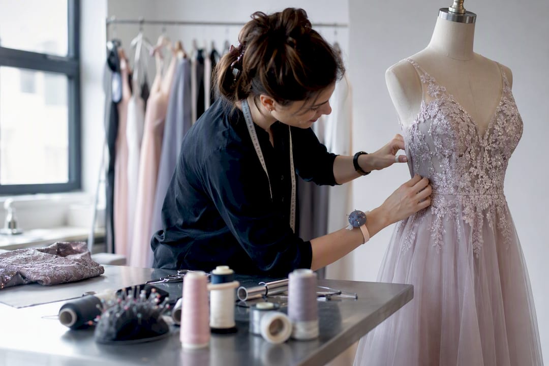 Tailor adjusting formal dress on mannequin