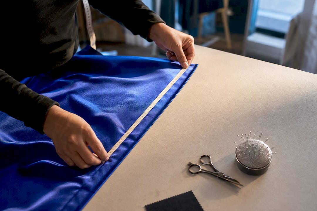 Measuring tape beside royal blue formal fabric