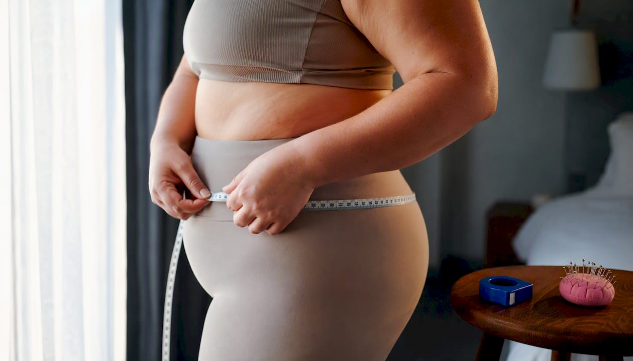 Woman checking hip measurement for formal fit