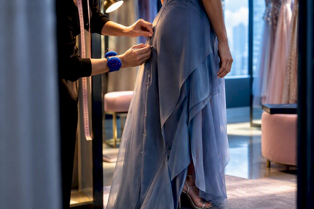 Tailor marking an evening gown seam