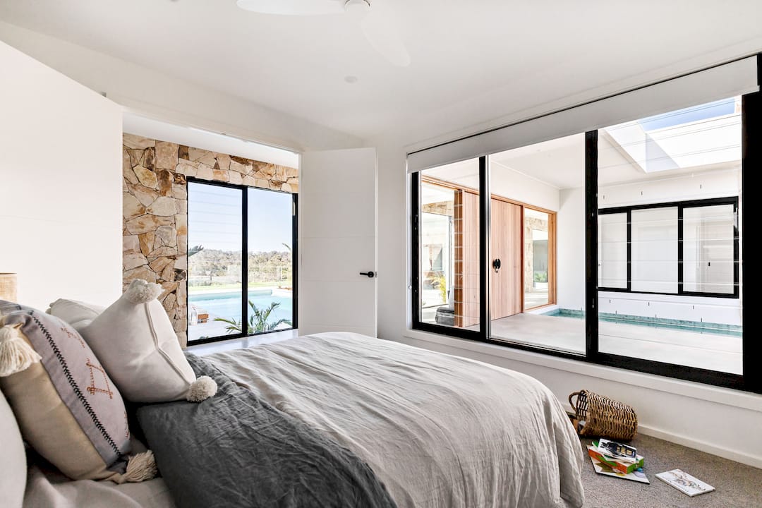 Installer fitting custom blinds in bedroom