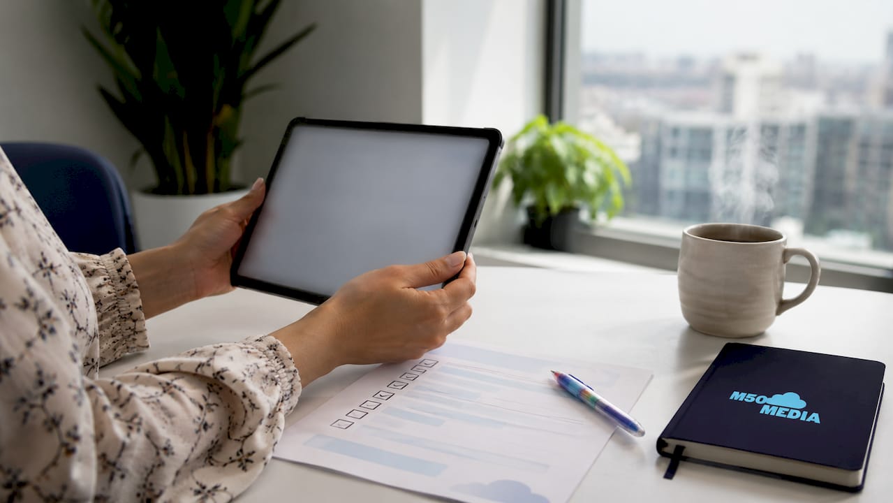 Hands holding tablet reviewing email campaign goals checklist