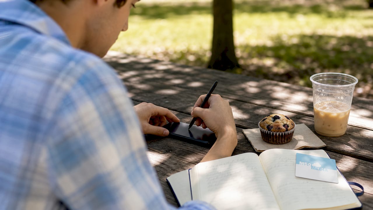 Hands scrolling smartphone with hashtag notes in cafe