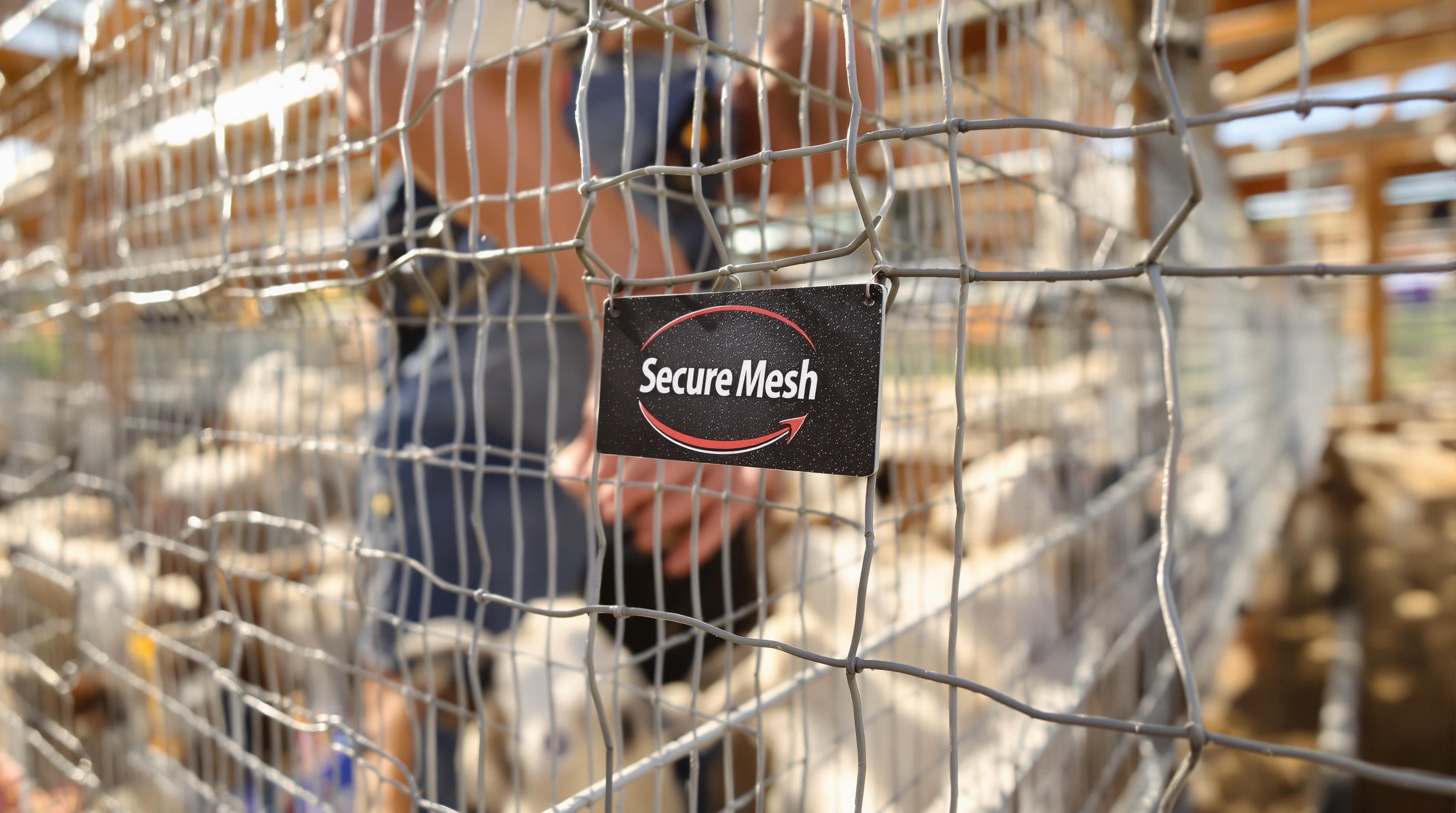Farmworker checks strong woven wire fence for goats