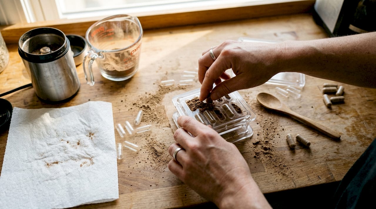 Hands using capsule filling machine with powder