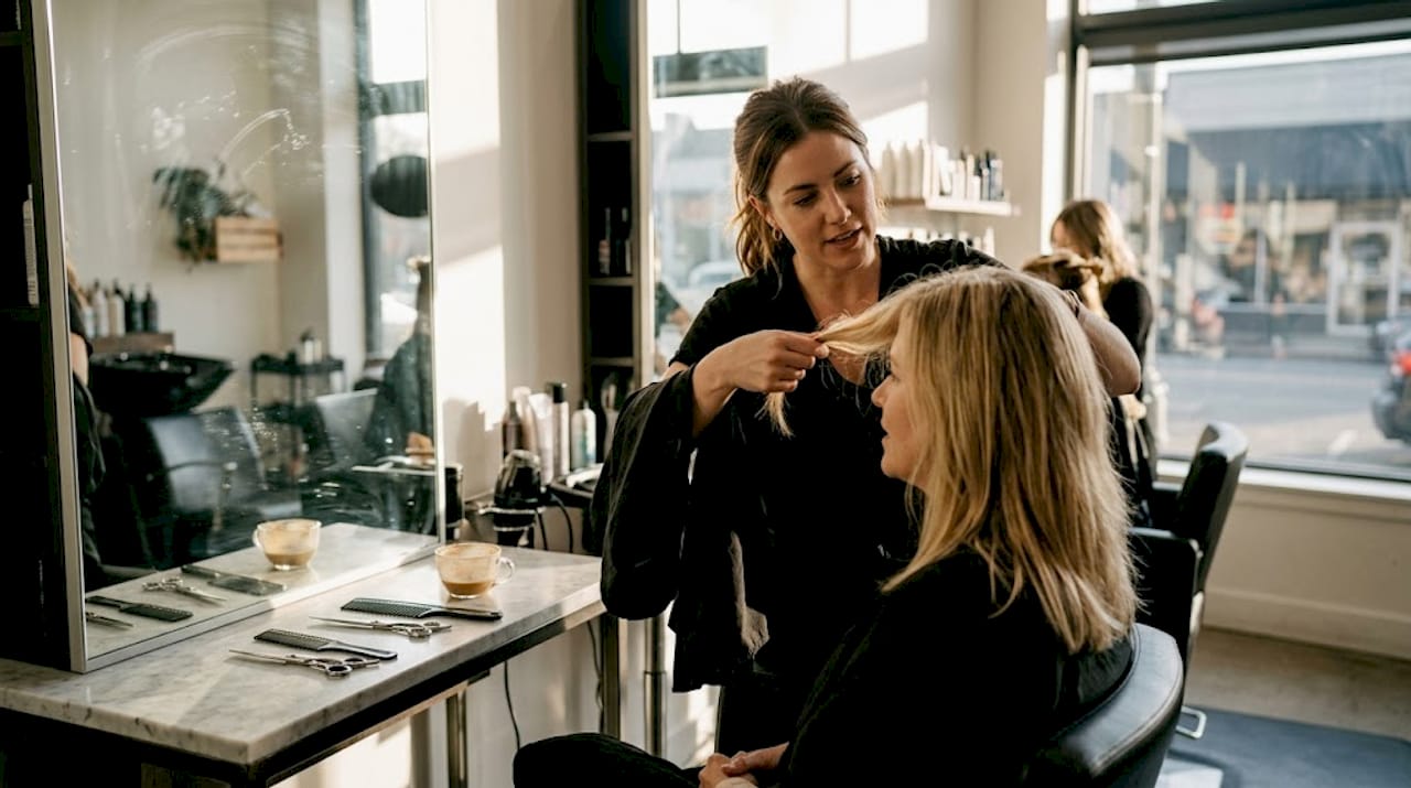 Stylist consulting client in real salon scene