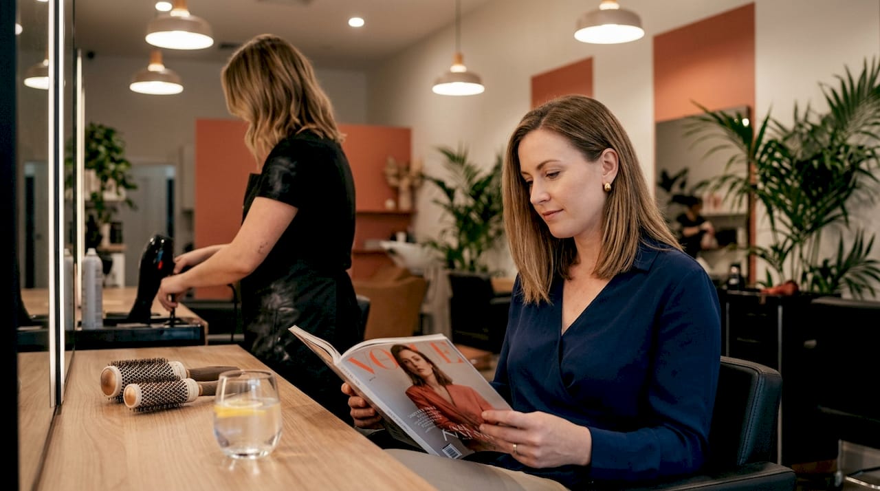 Woman receiving blowout in modern hair studio