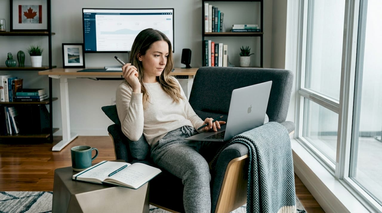 Woman using vape pen at home with laptop