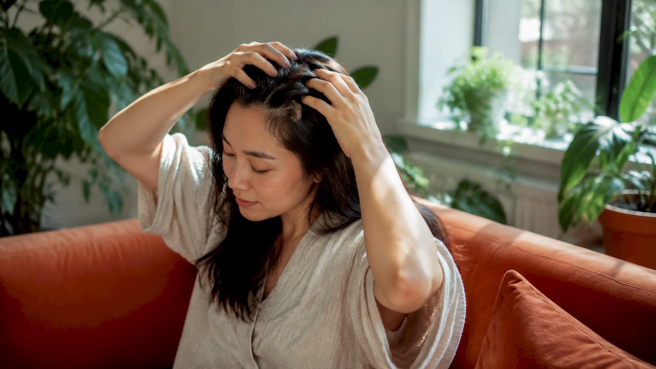 Woman applying scalp oil before coloring
