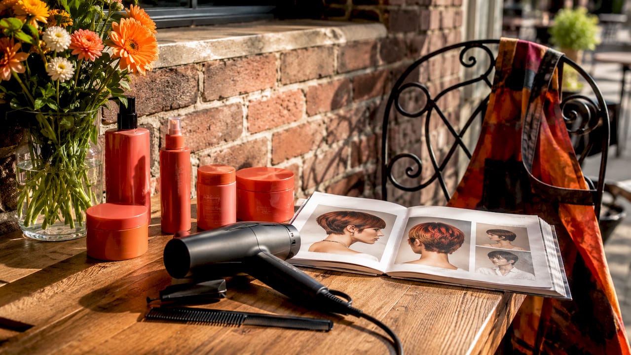 Styling tools arranged on wooden table near chair