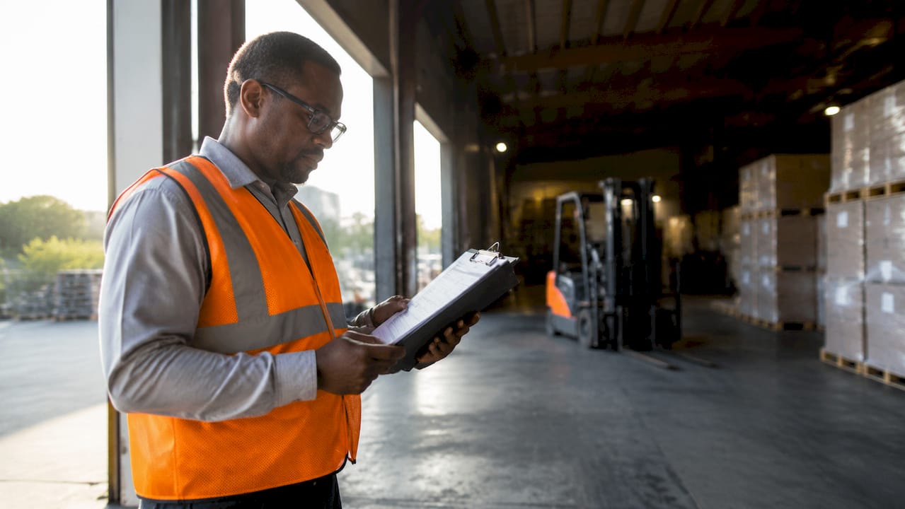 Warehouse supervisor reviewing OSHA compliance checklist