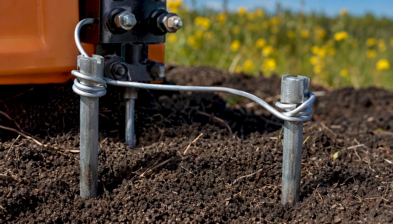 Close-up of electric fence grounding rods and wire