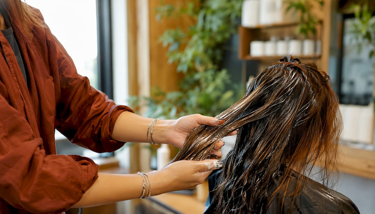 Stylist applying bond-building hair treatment