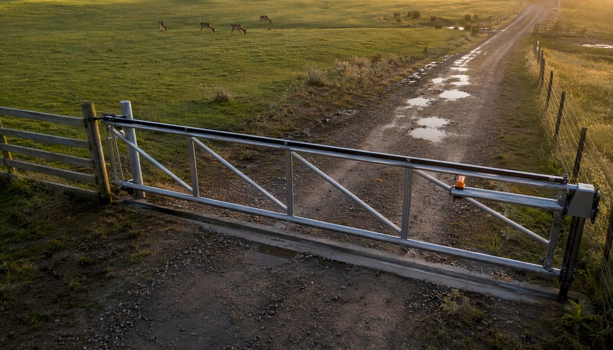 Wide view of cantilever farm gate on rural driveway