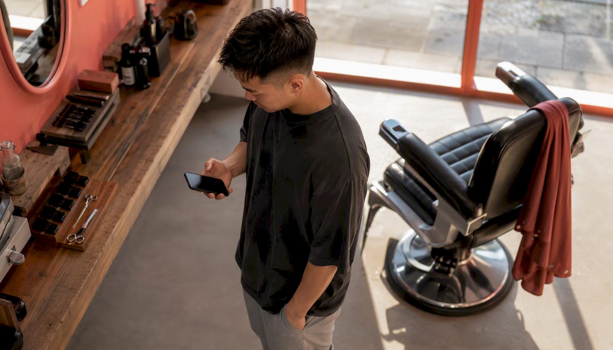 Man booking haircut appointment on smartphone