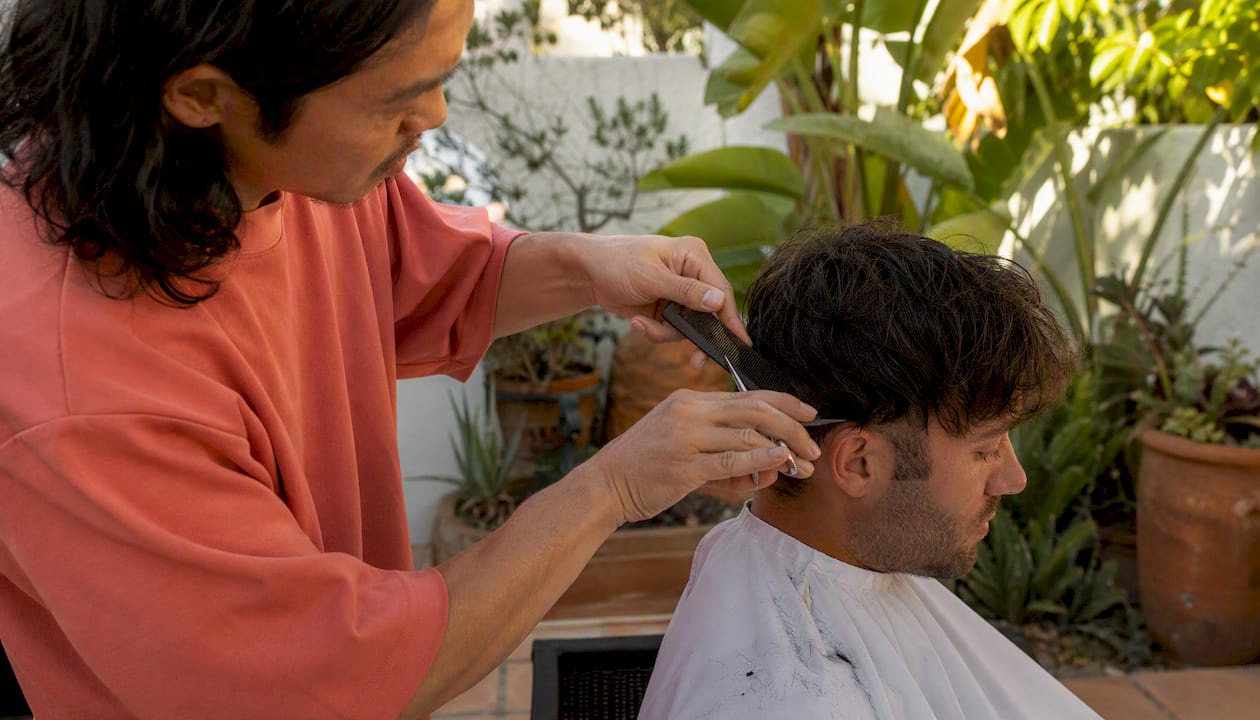 Hairstylist cutting hair using scissor-over-comb technique