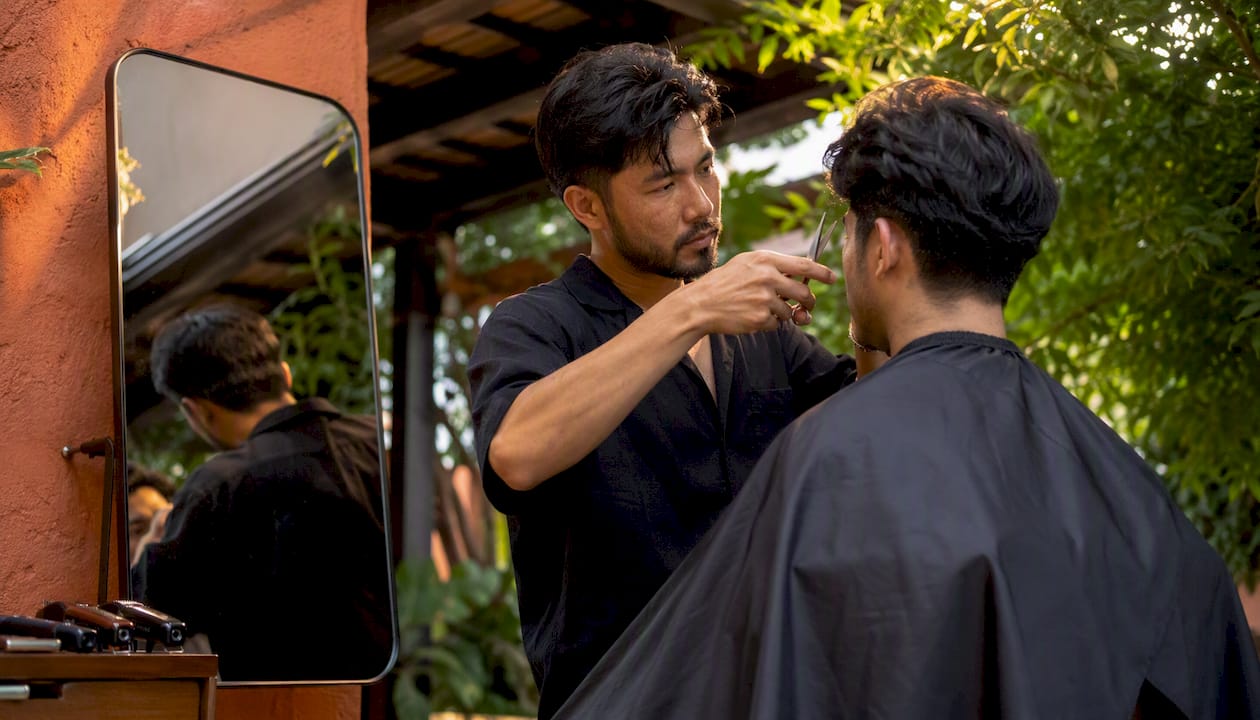 Barber cutting men's hair in salon