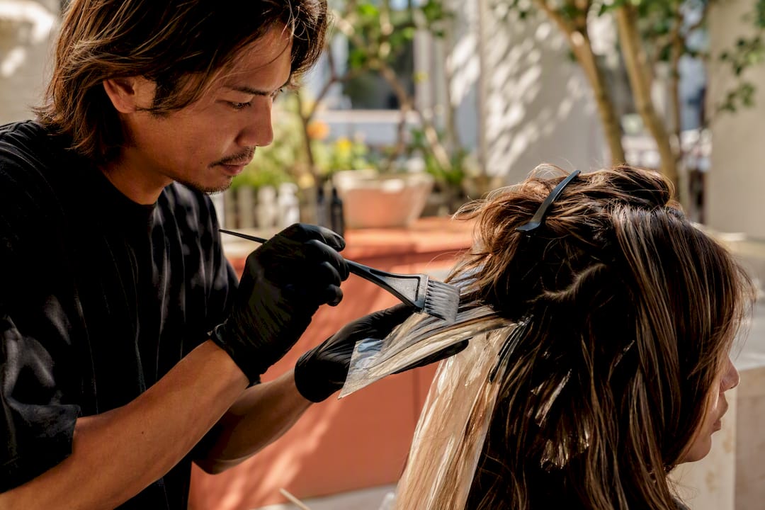 Stylist applying balayage in luxury salon