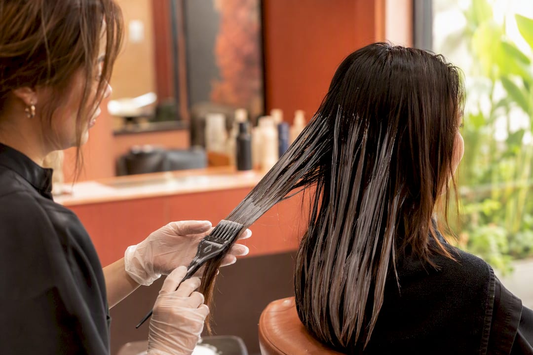 Stylist applying chemical bond hair treatment