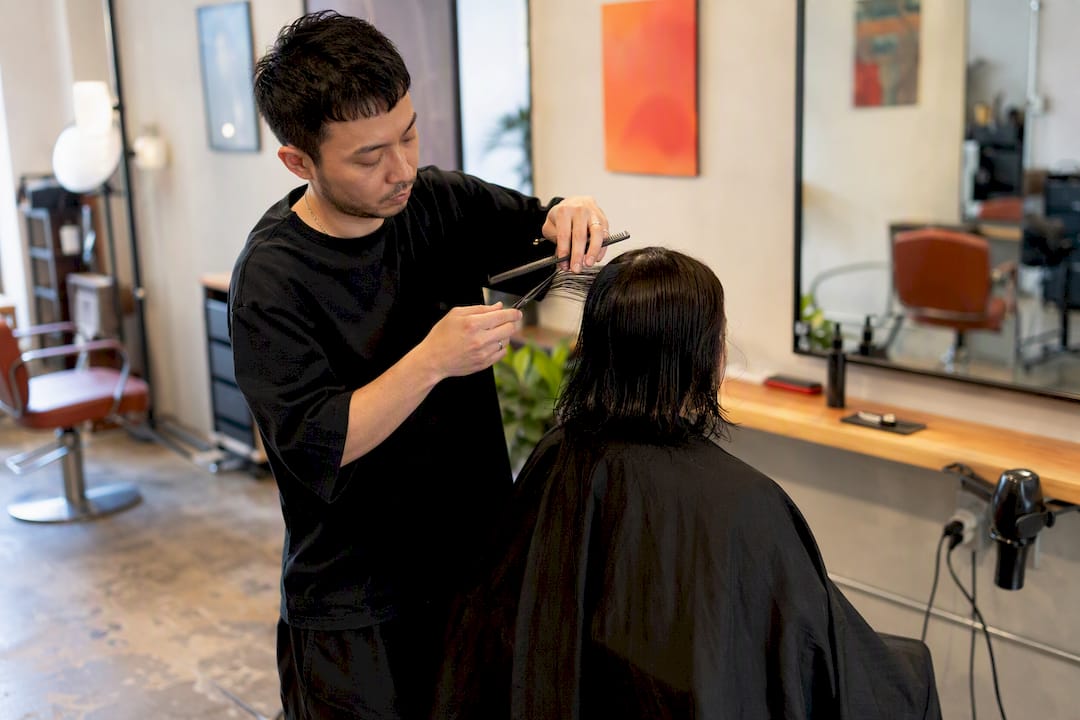 Stylist trimming hair at budget independent salon