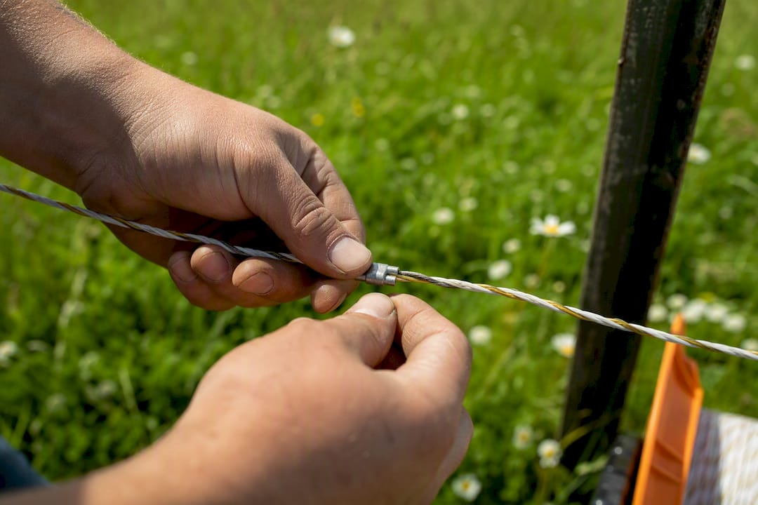 Hands splicing polywire on reel close-up