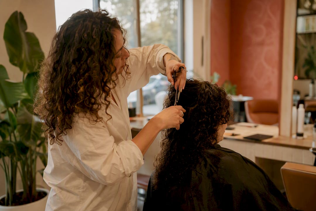 Stylist cutting curly hair close-up