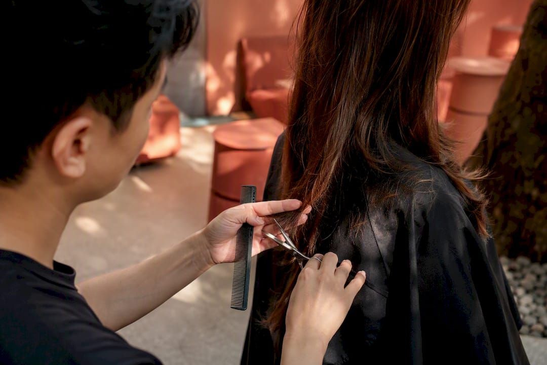 Stylist giving a precision haircut in warm salon
