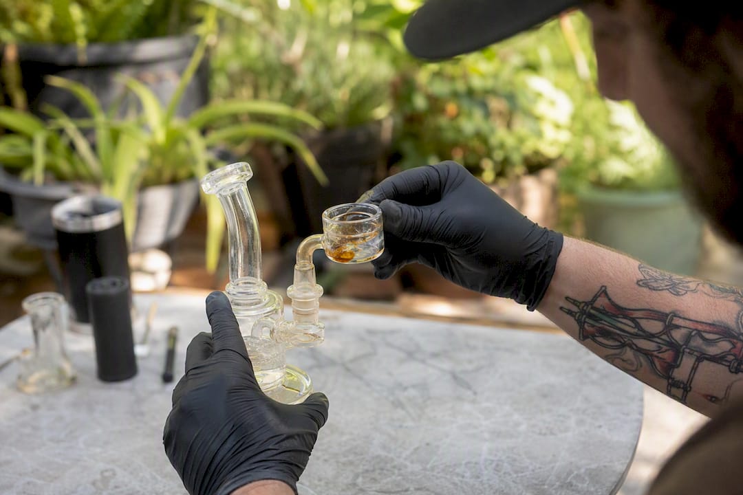 Hands removing reclaim catcher dish with residue
