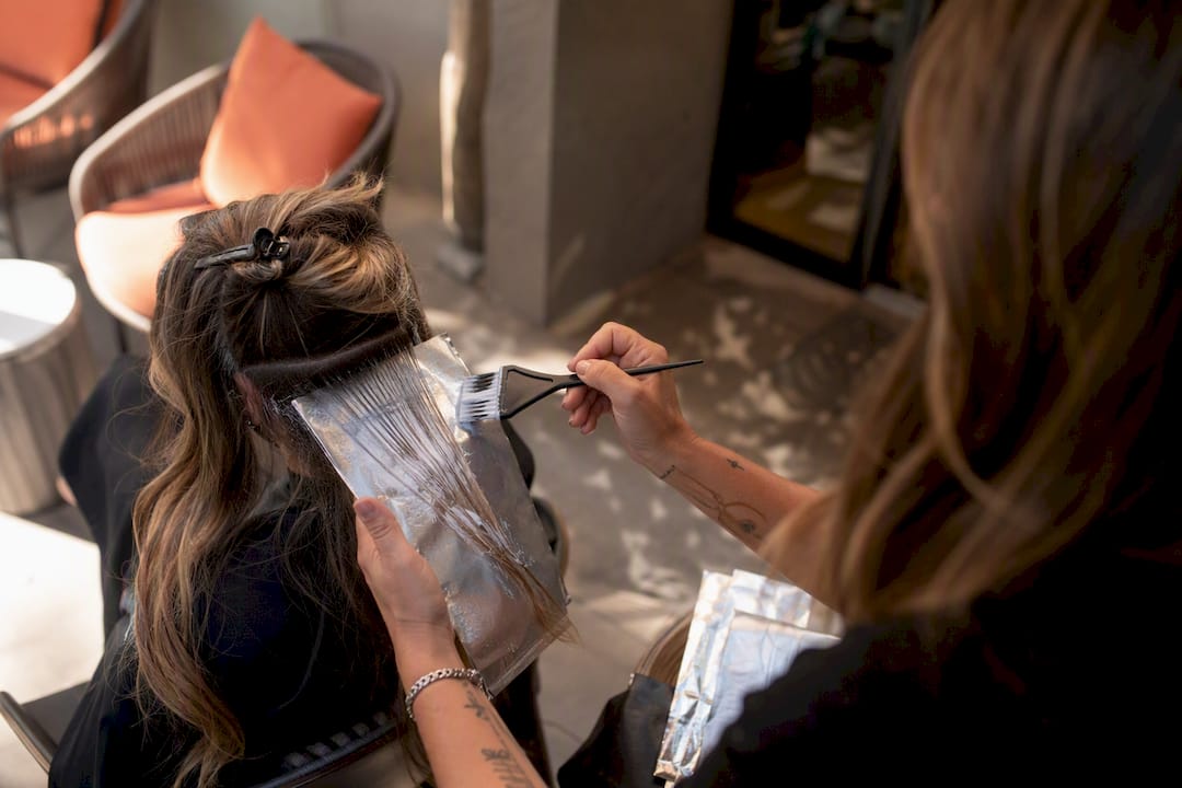 Stylist applying balayage highlights in salon