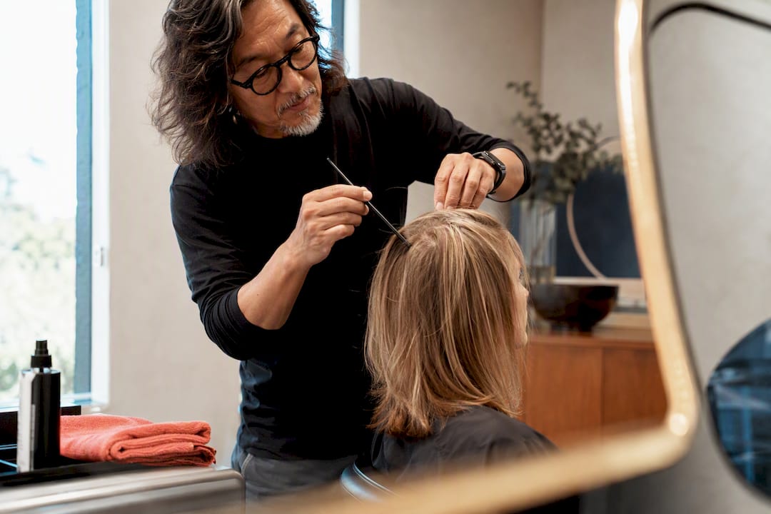 Stylist assessing fine hair during consultation
