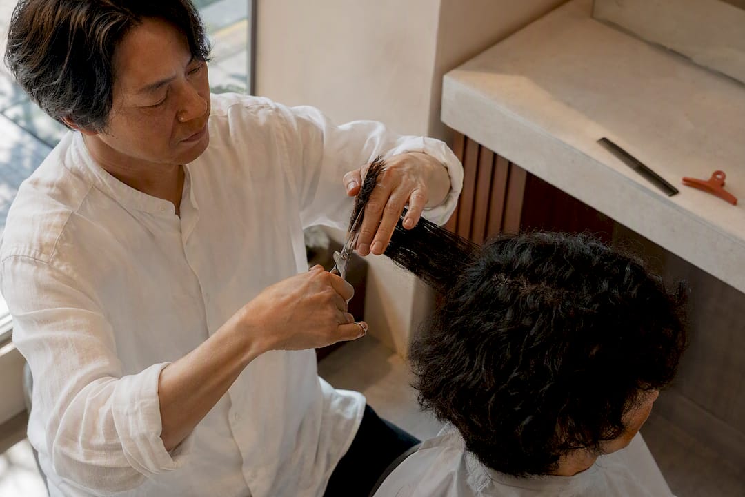 Stylist shaping textured hair with precision