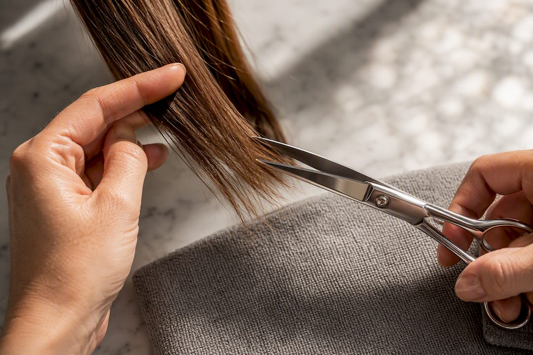 Stylist trimming visibly split hair ends