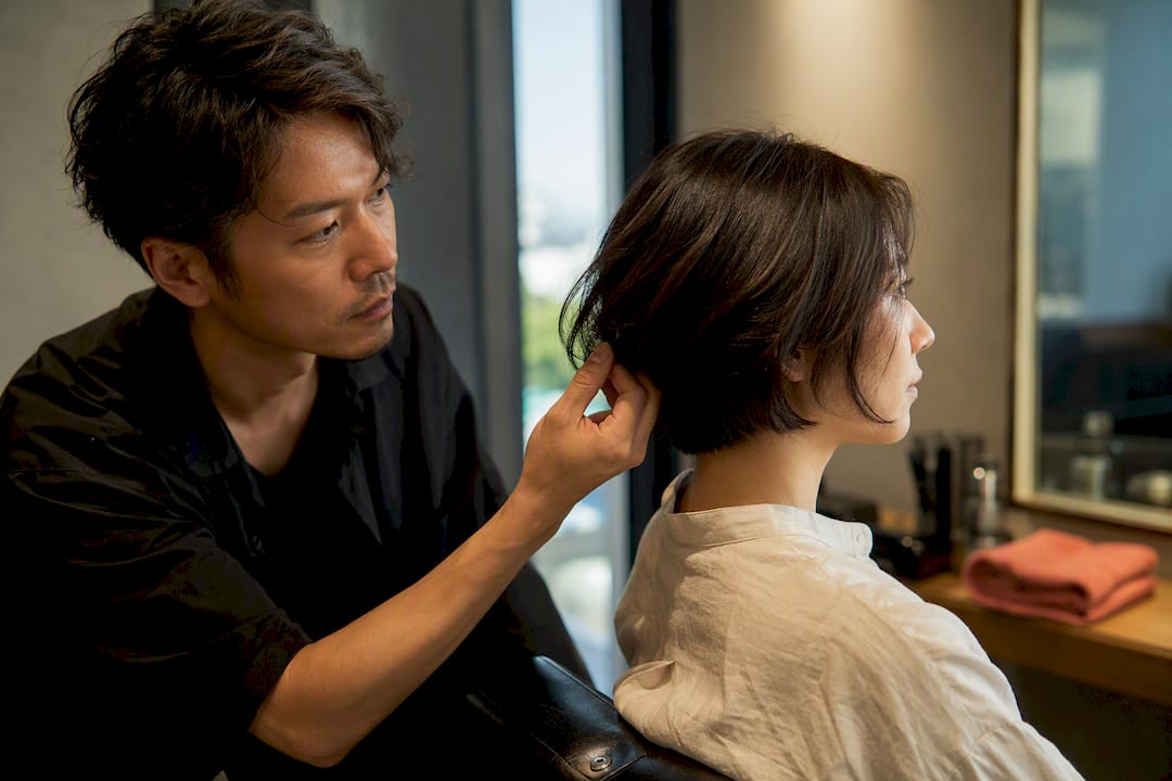 Stylist assessing hair during consultation