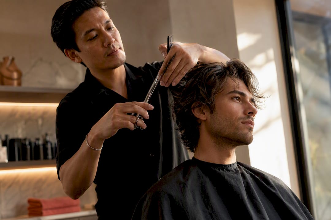 Stylist shaping textured men's haircut