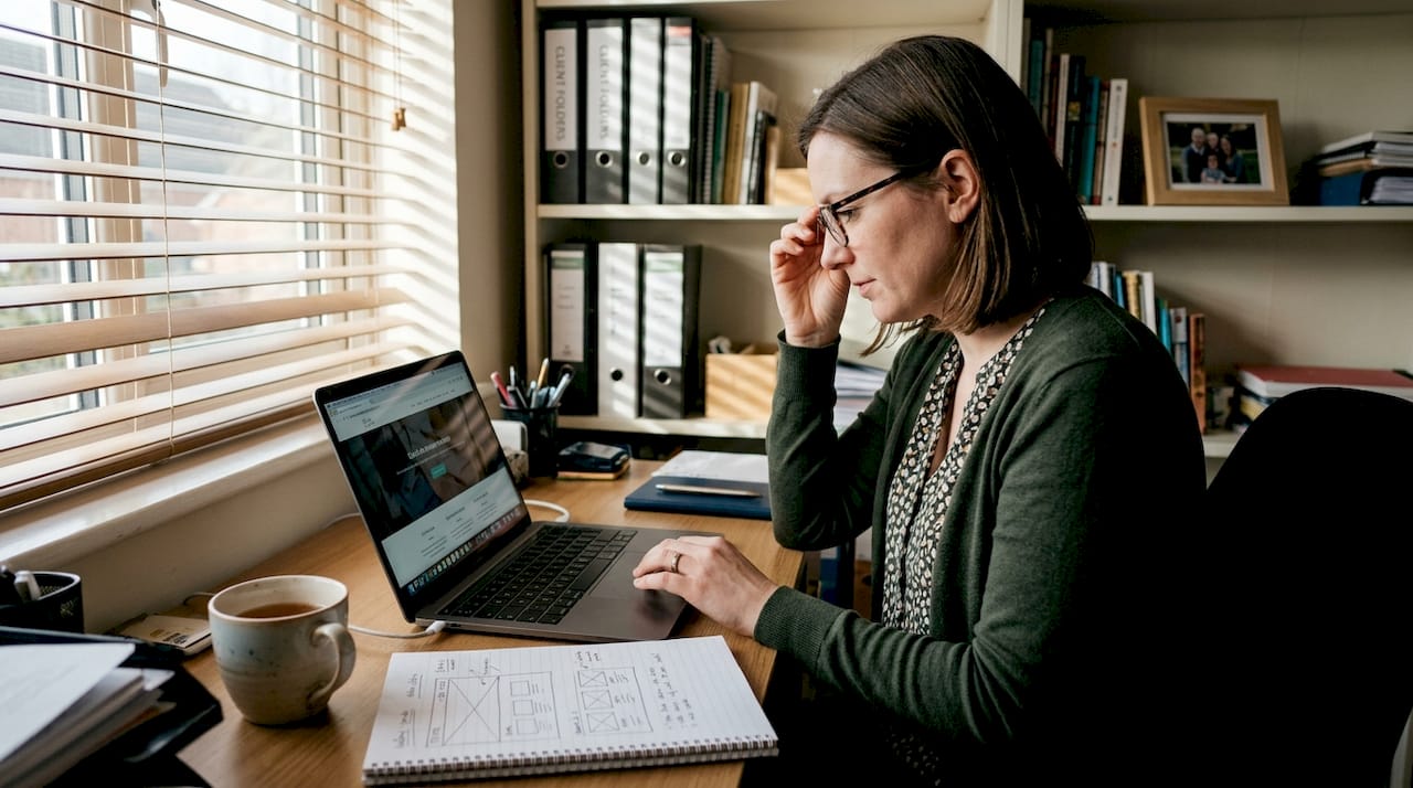 Business owner reviewing website at home desk