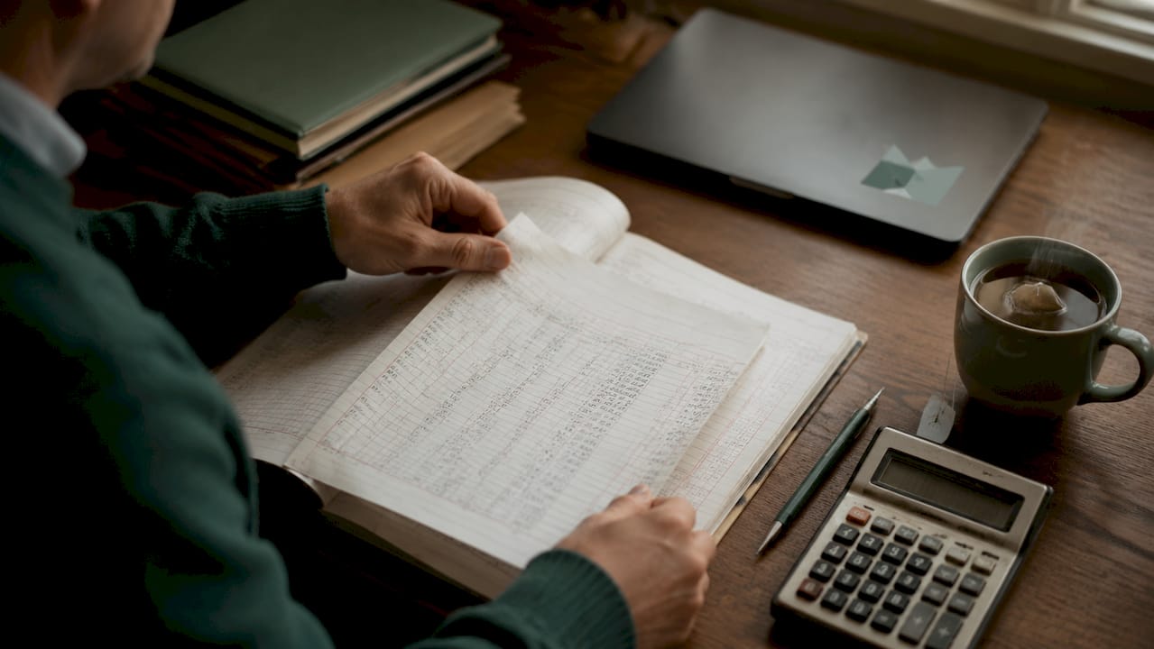 Hands flipping machinery depreciation ledger