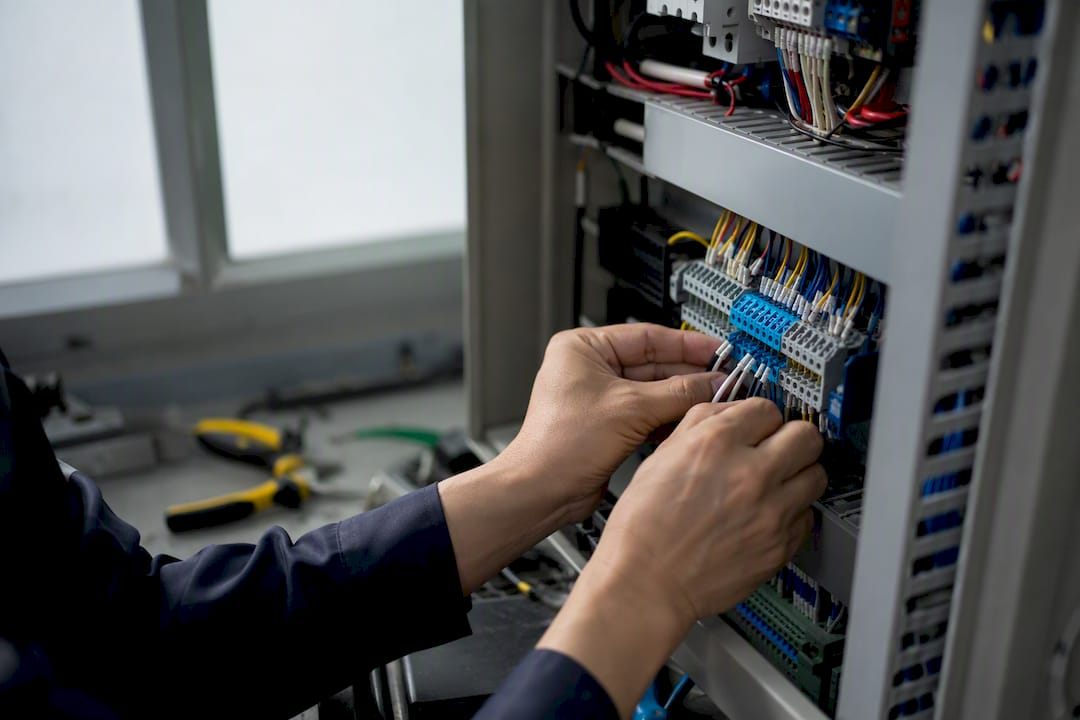 Hands routing industrial control panel cables