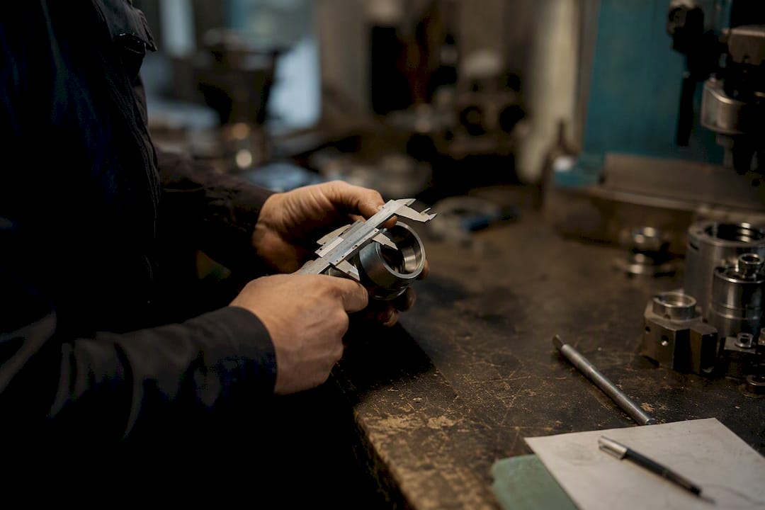 Hands measuring factory part for quality control