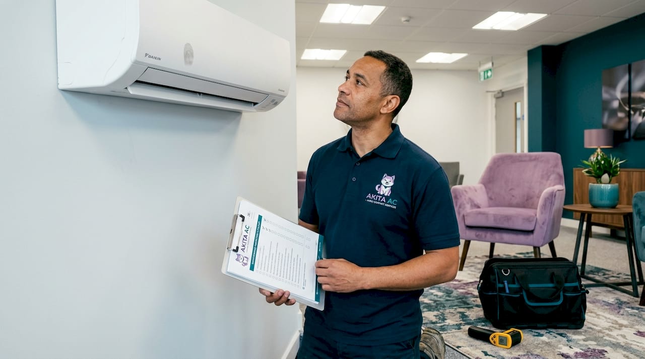 Technician checking office wall air conditioner