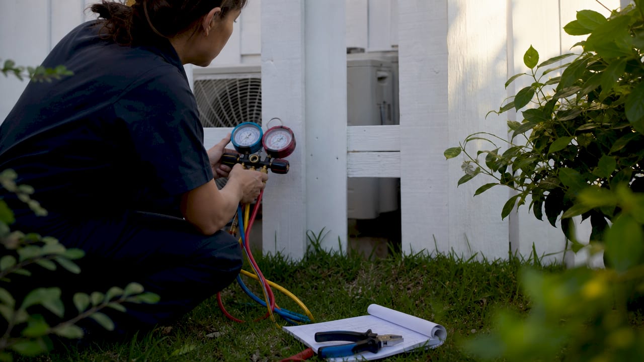 Technician testing home air conditioner gauges