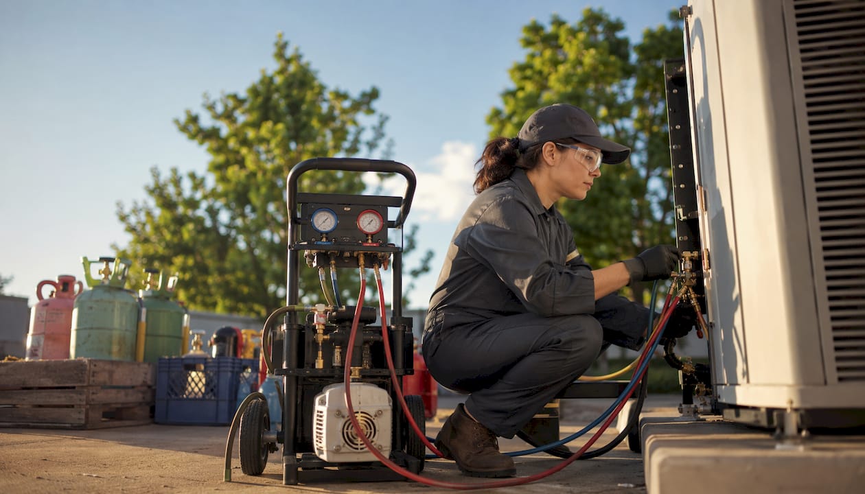 Refrigerant recovery technician working inside service van