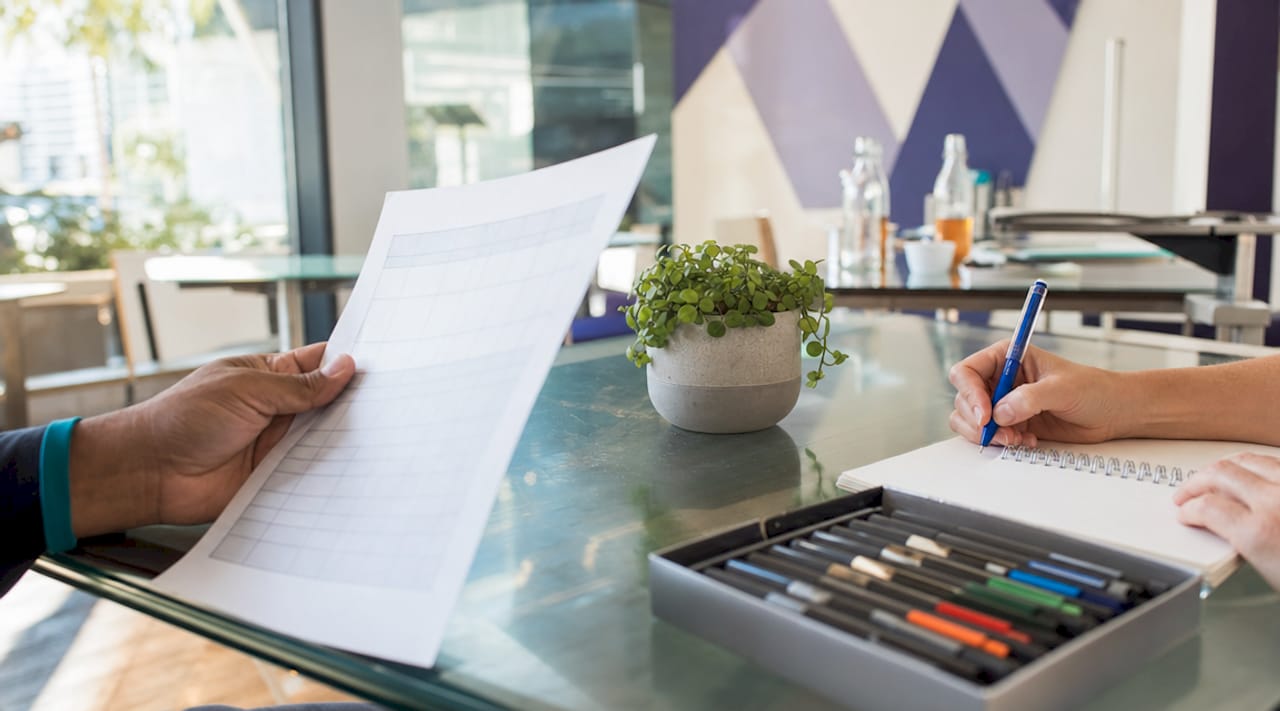 Hands managing board conflict registers at meeting table