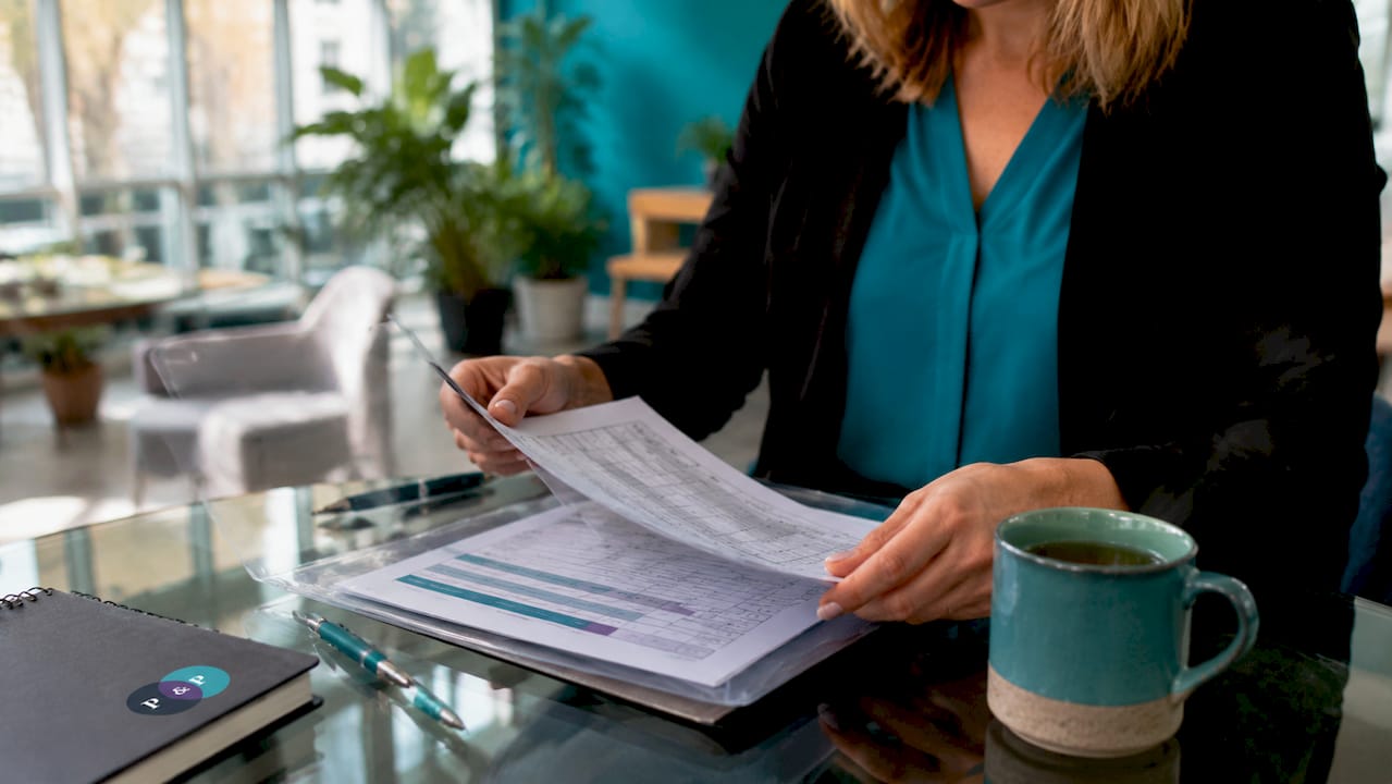 Hands preparing audit paperwork in boardroom