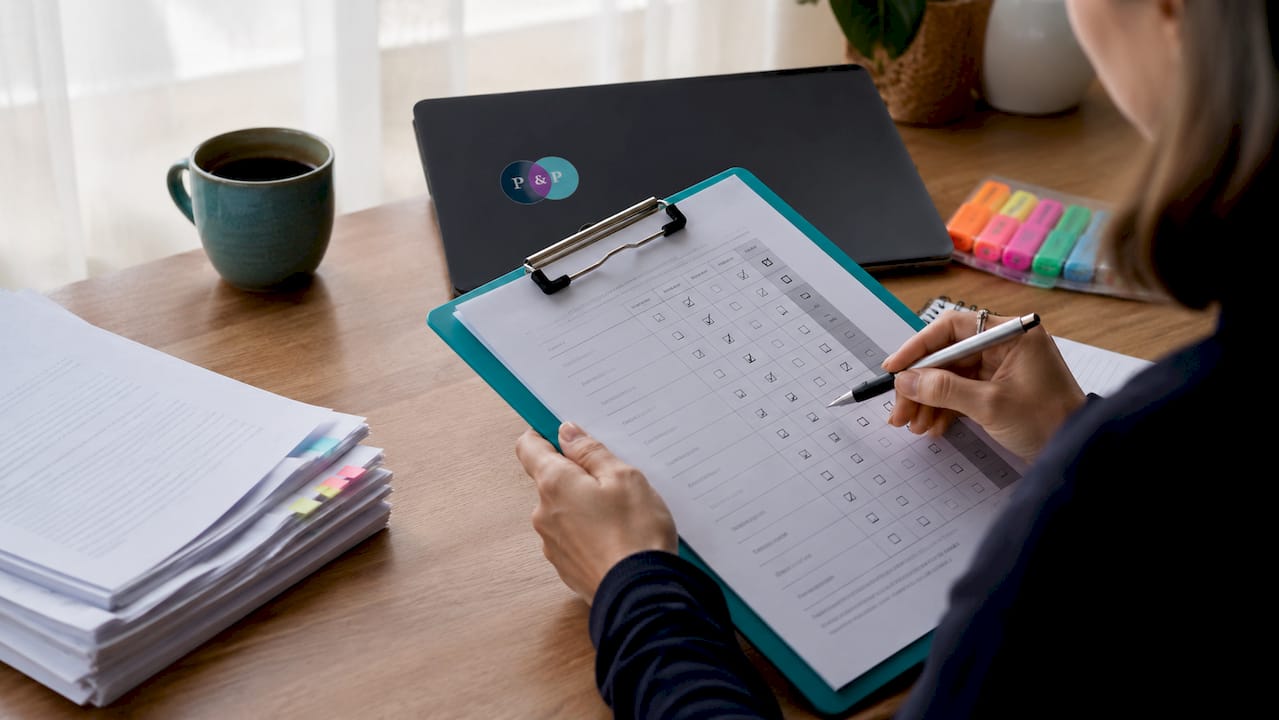 Hands checking off compliance checklist for tender