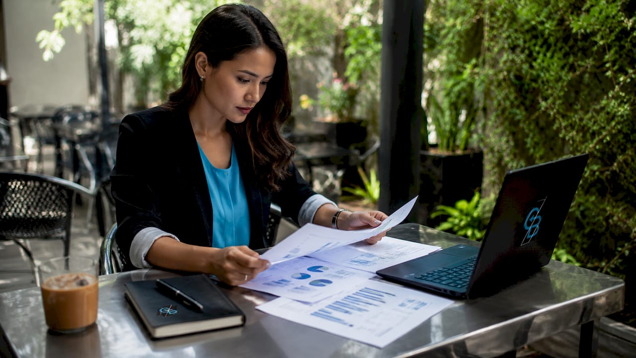Hands organizing sales forecasting documents