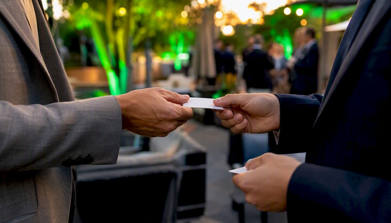 Hands exchanging business cards at networking event